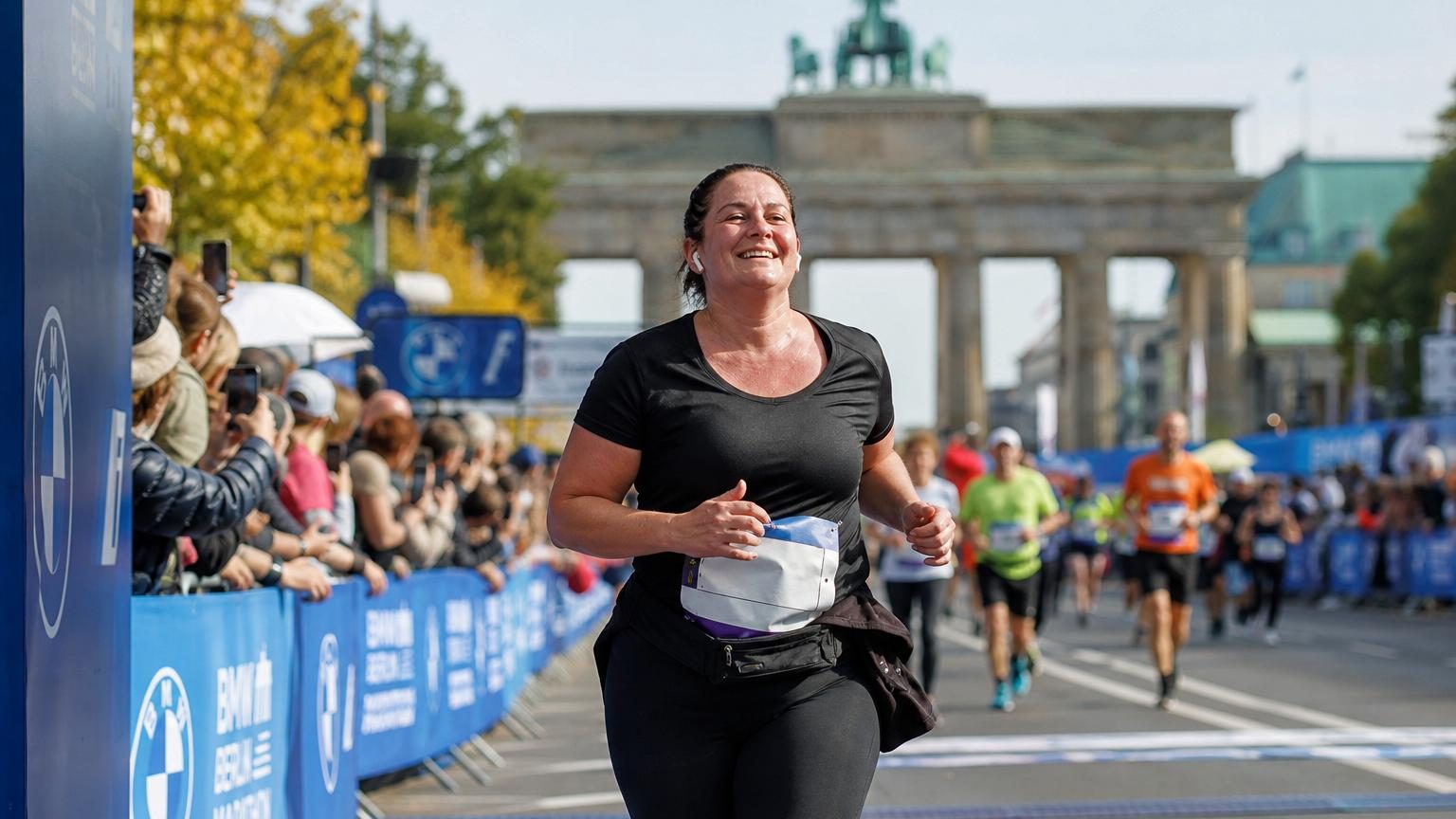 Coureuse en action lors du marathon de Berlin, avançant à son propre rythme sans obsession de chronométrage