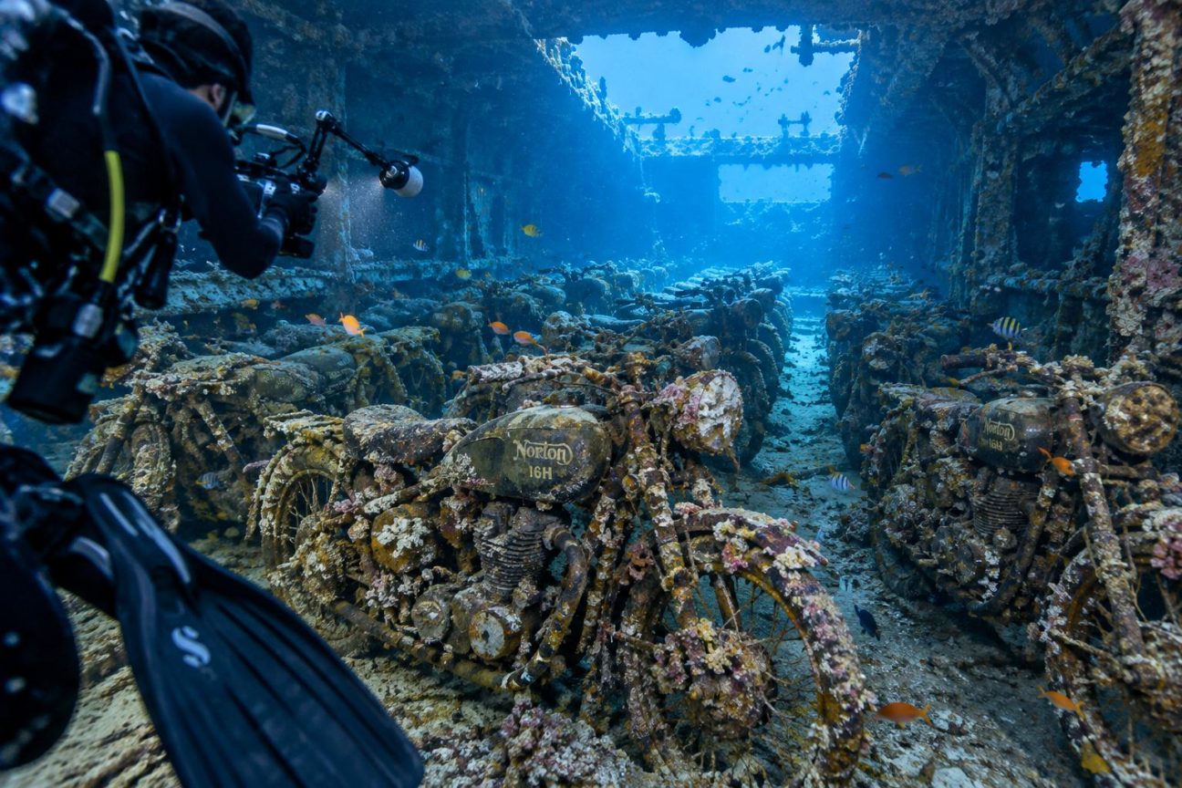 Motos Norton 16H alignées au fond de la mer, recouvertes de coraux et d'algues, entourées de poissons, dans l'épave du cargo britannique SS Thistlegorm en mer Rouge