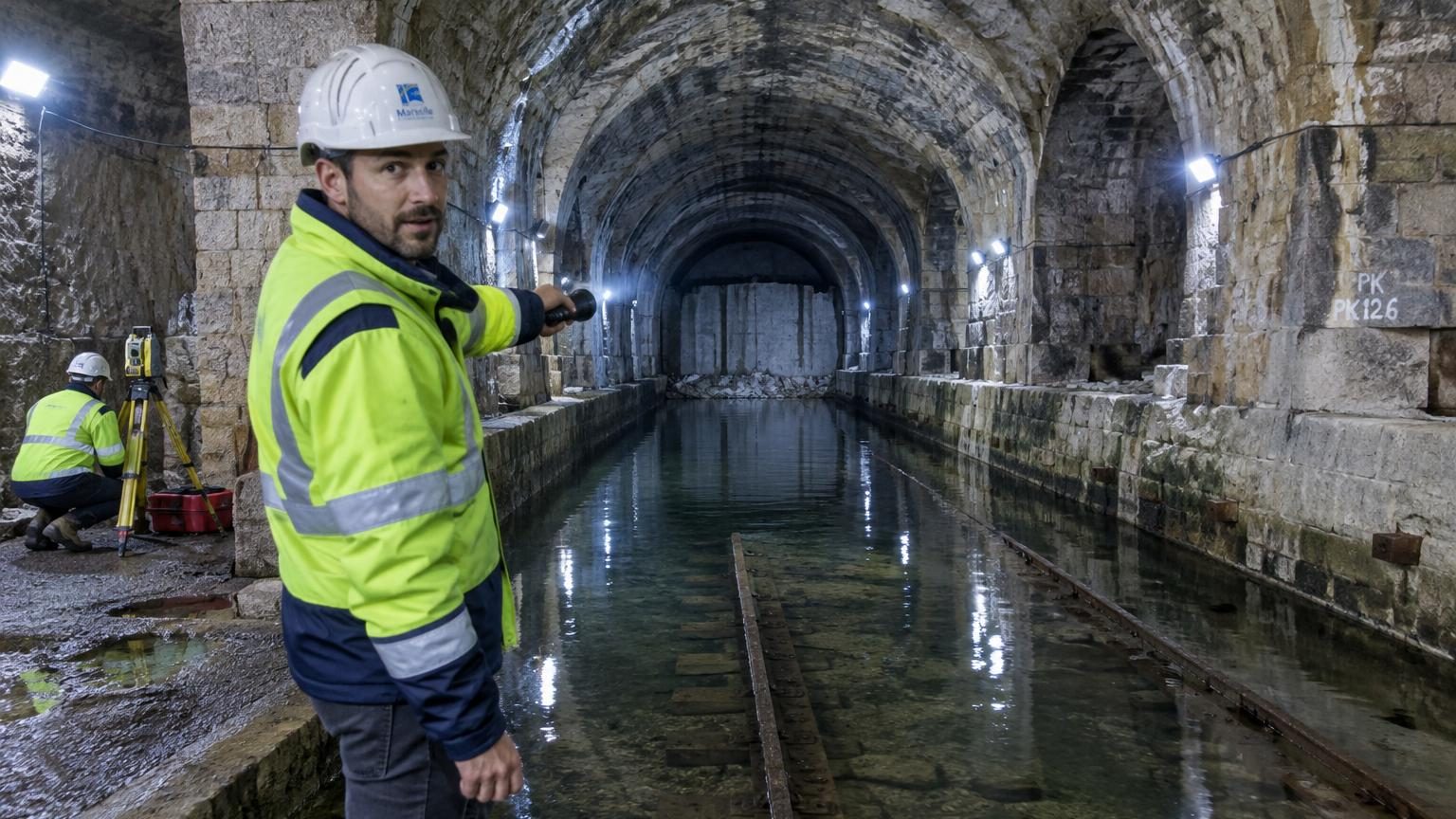 Vue d'une galerie souterraine en béton sous Marseille, galerie large et voûtée creusée dans la roche, symbole d'un ouvrage industriel géant enfoui sous la surface.